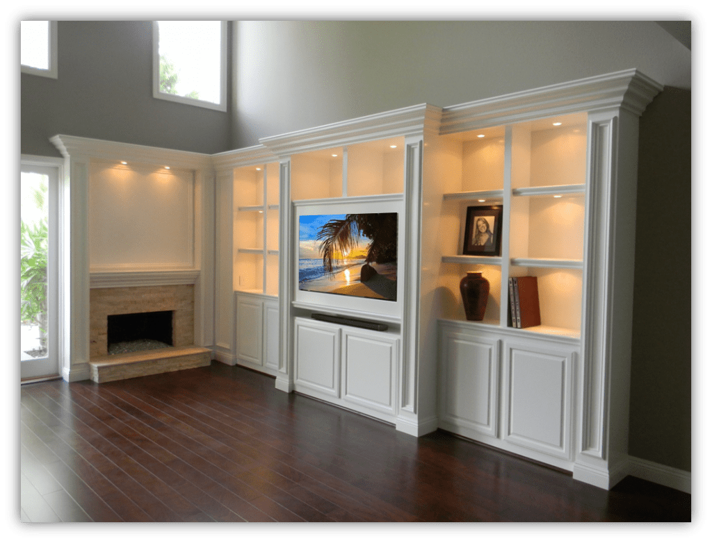 A living room with white built in cabinets and a fireplace.