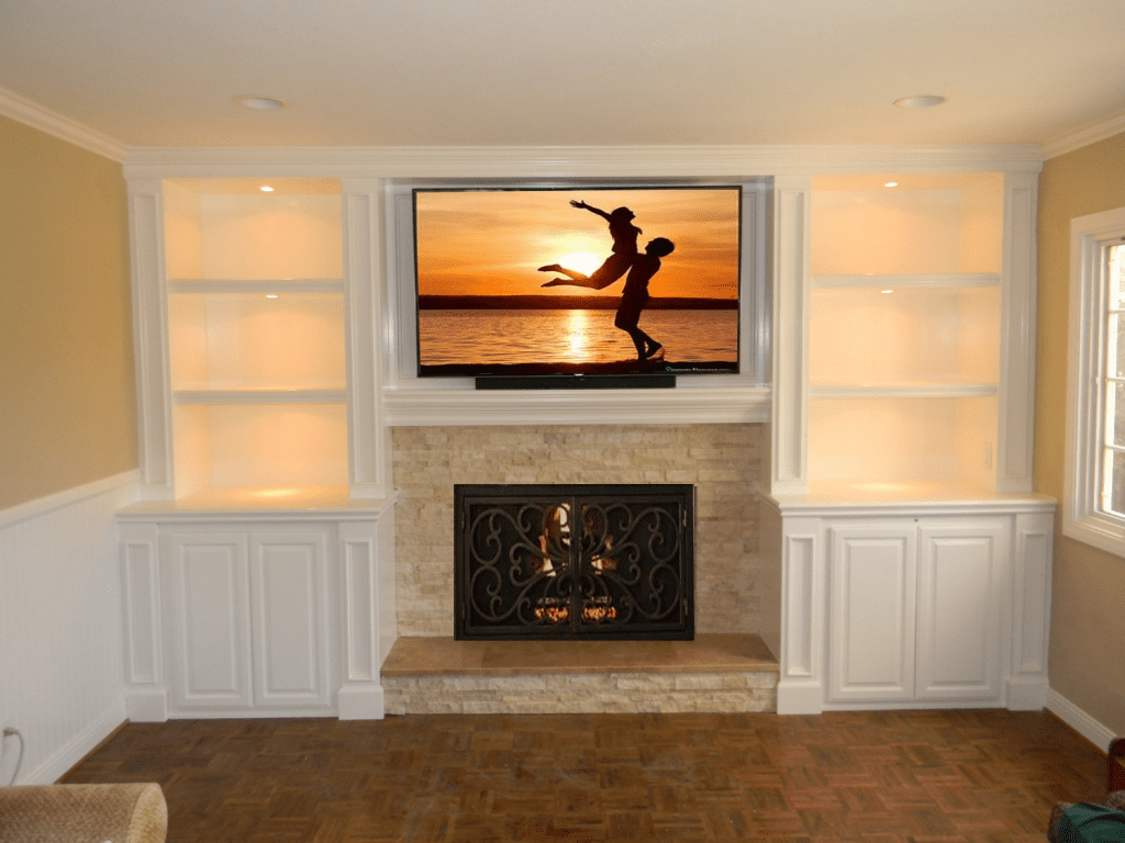 A flat screen tv mounted to the wall above a fireplace.