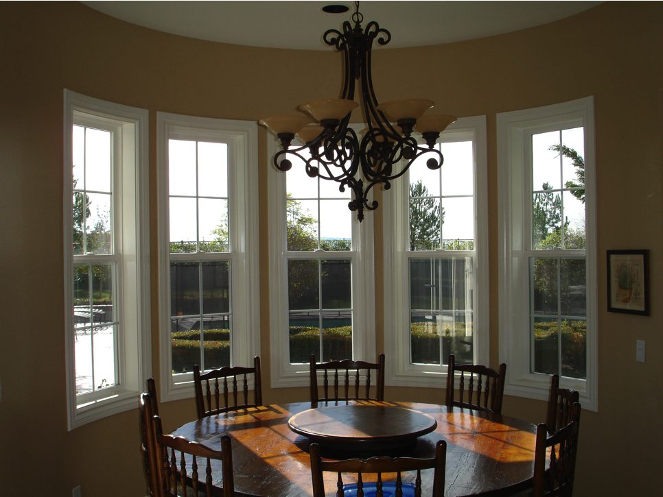 A dining room with six chairs and a round table.