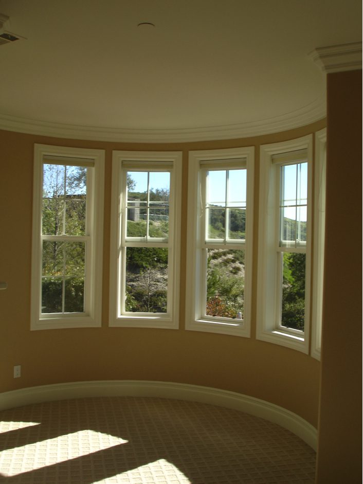 A room with several windows and a circular window.