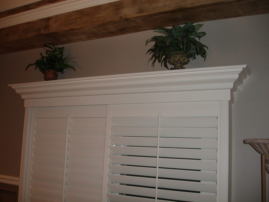 A white cabinet with plants on top of it.