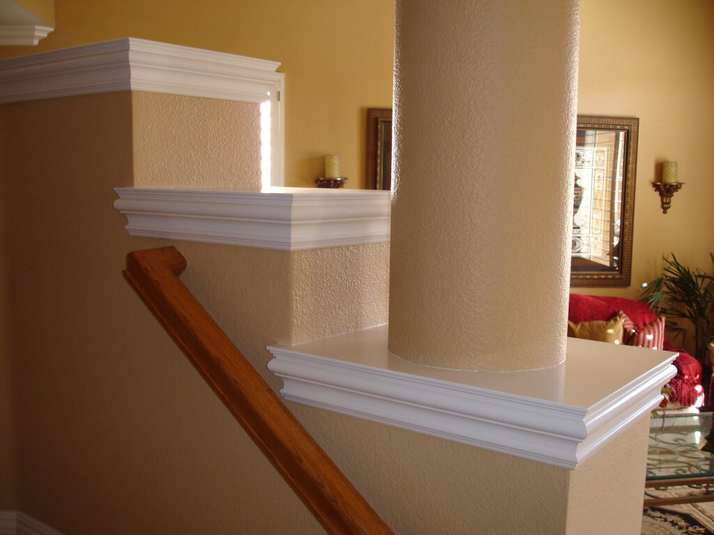 A staircase with white trim and wooden handrail.