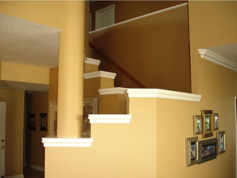 A staircase with white steps and yellow walls.