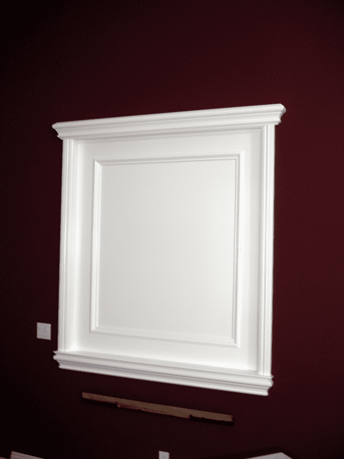 A white mirror hanging on the wall in a room.