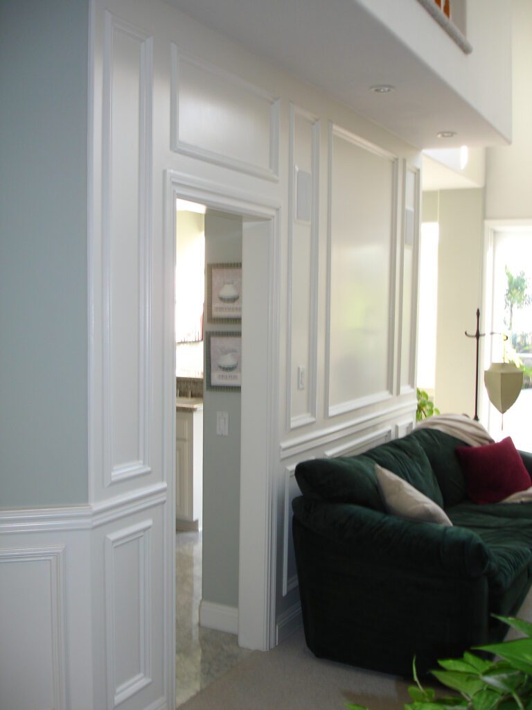 A living room with white walls and green couch.