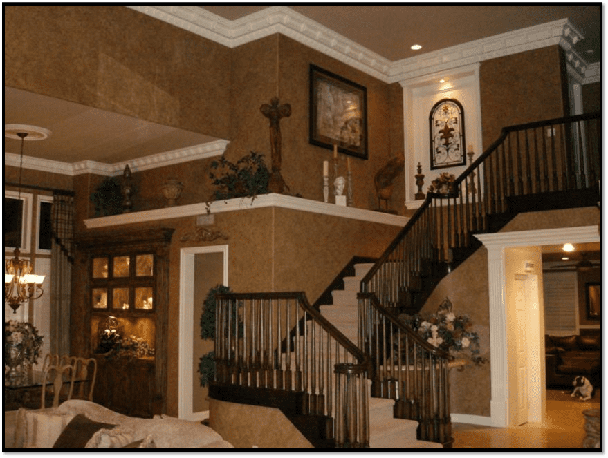 A living room with stairs and a wall of paint.