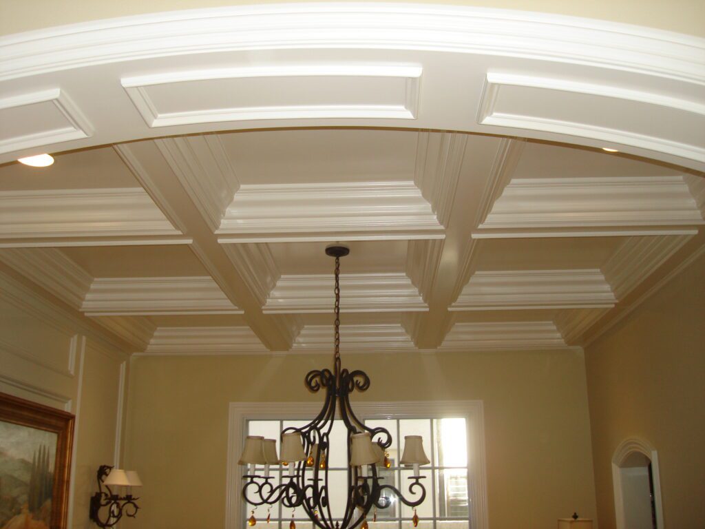 A chandelier in the center of a room with white walls.