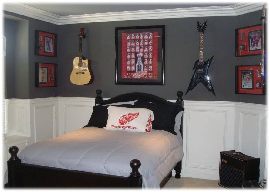 A bedroom with two guitars hanging on the wall.