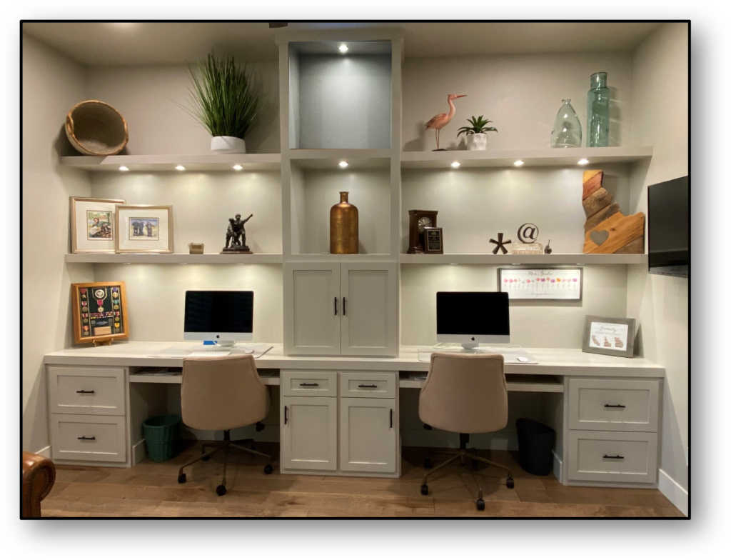 A room with two desks and shelves filled with computers.