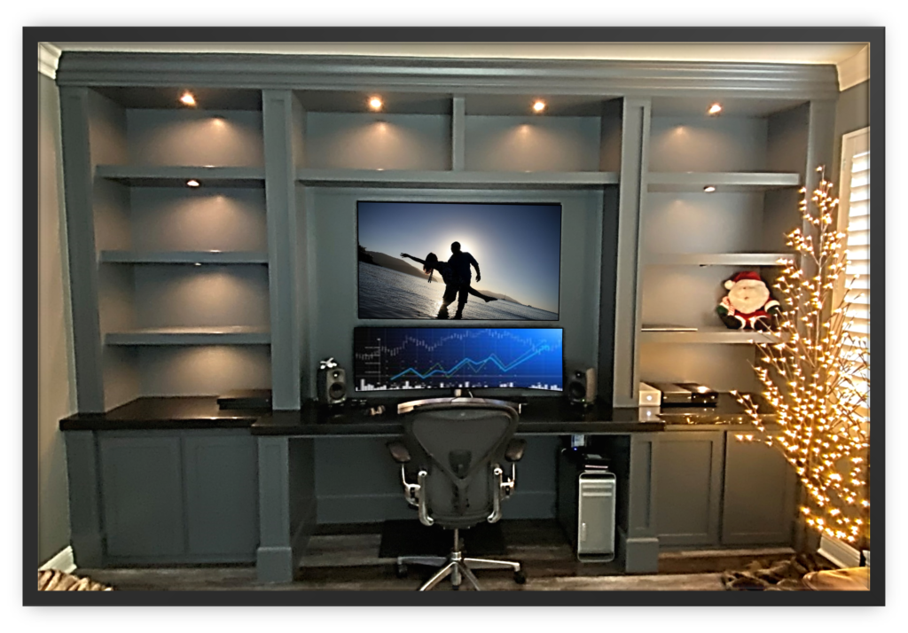 A computer desk with a large screen television on top of it.