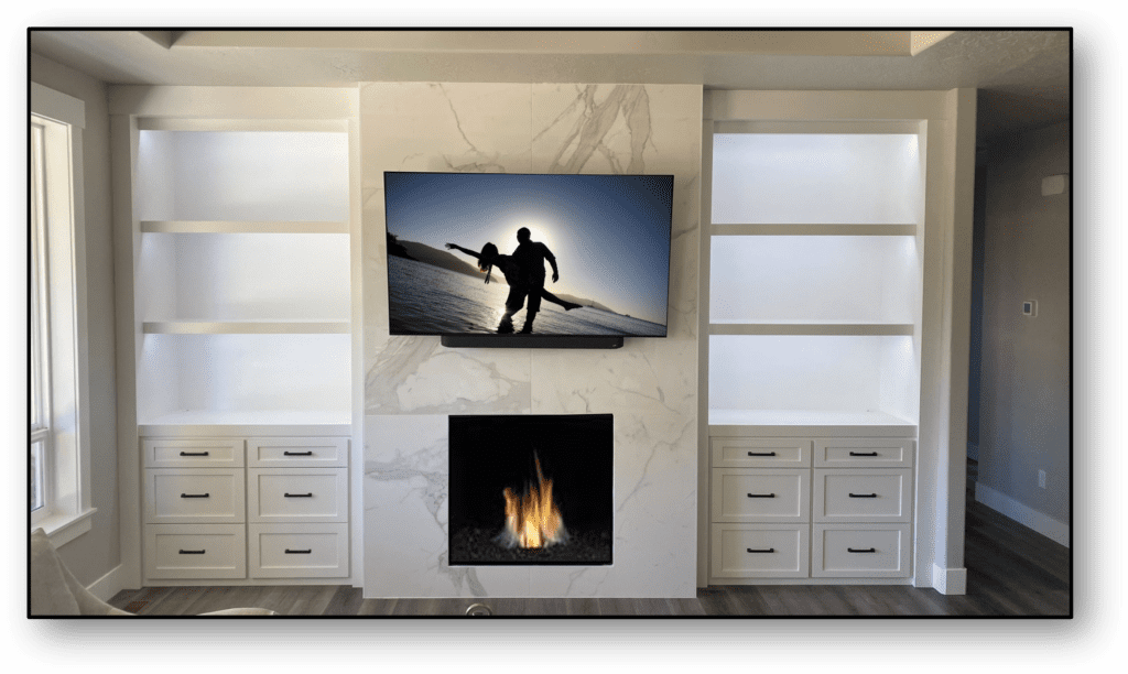 A television mounted on the wall above a fireplace.