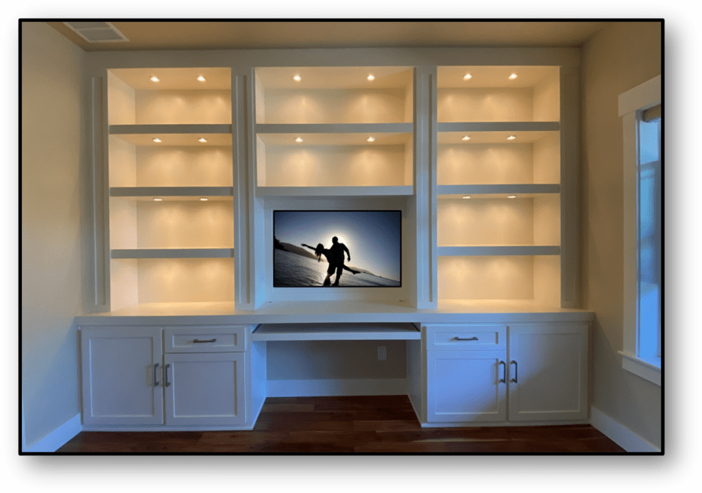 A television mounted on the wall above a desk.