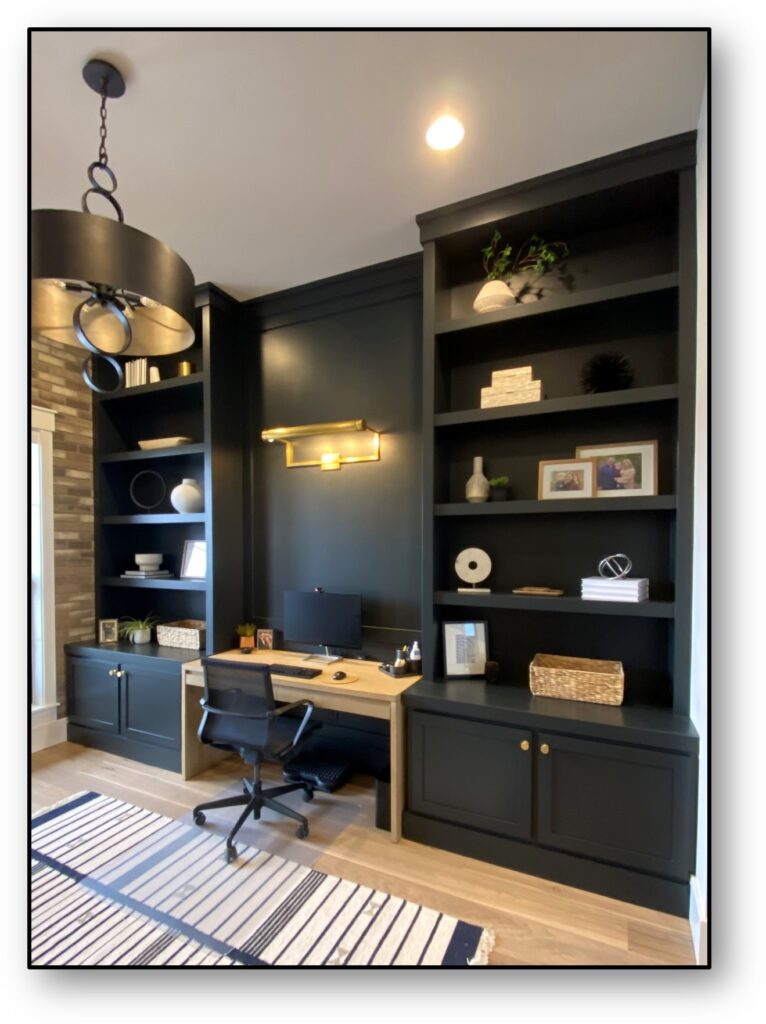 A black wall with shelves and a desk in the center.