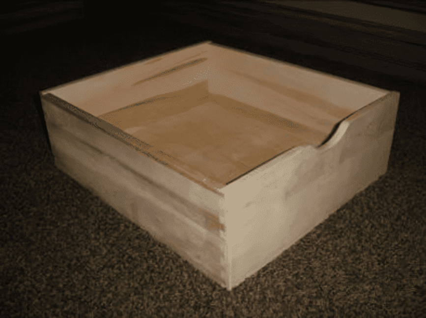 Wooden box on carpeted floor.